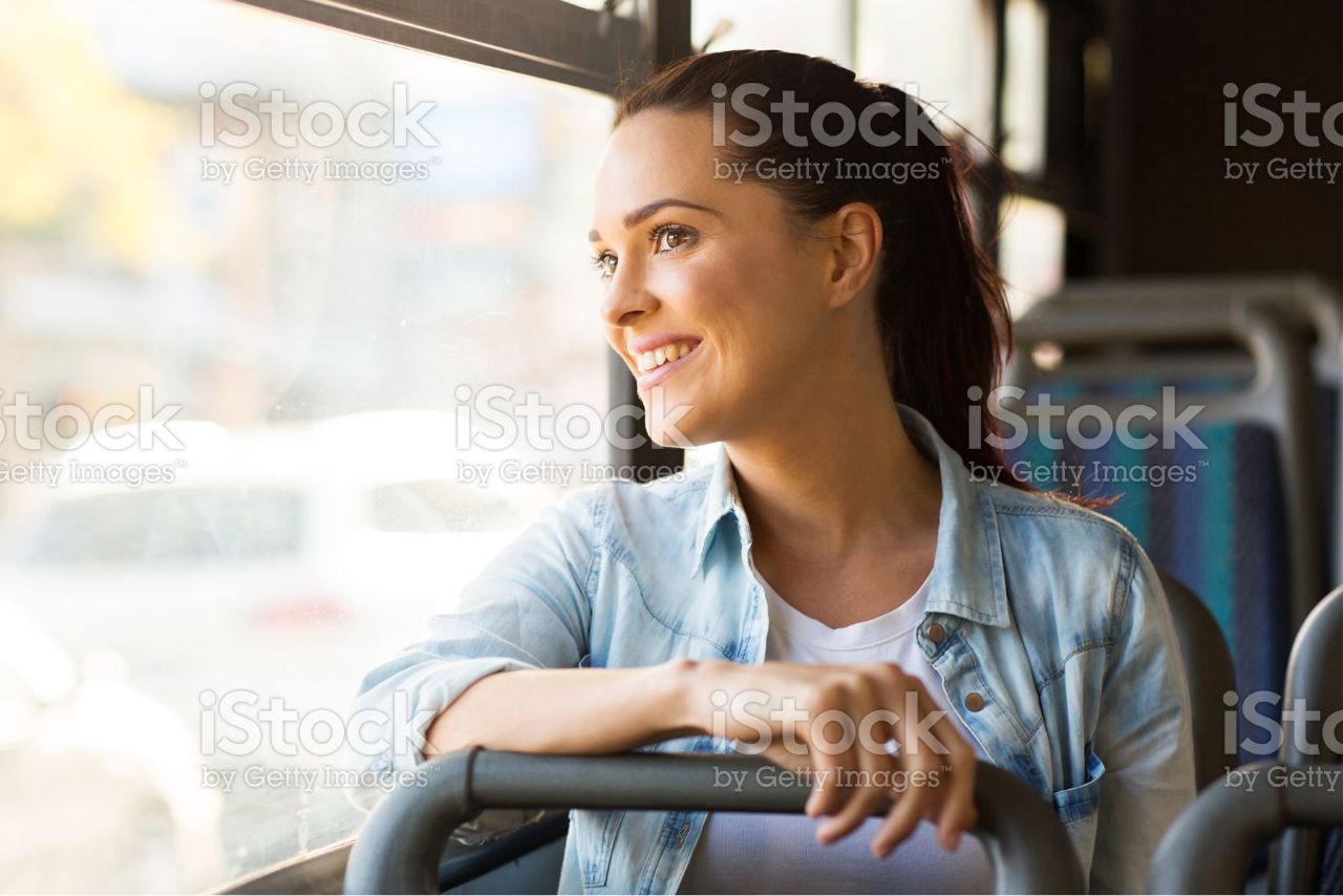 Bus riding woman happily looking out bus window
