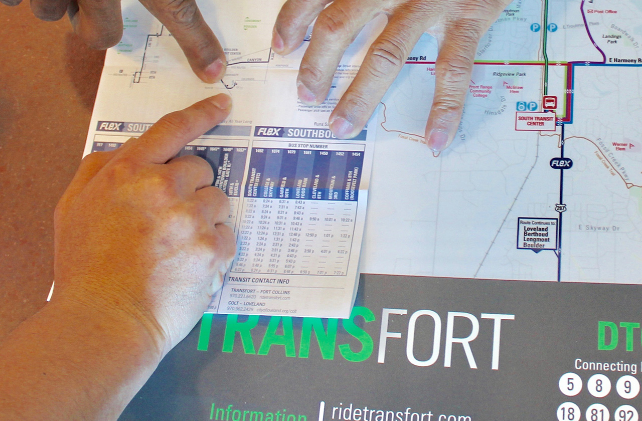 two people pointing at a bus map and schedule