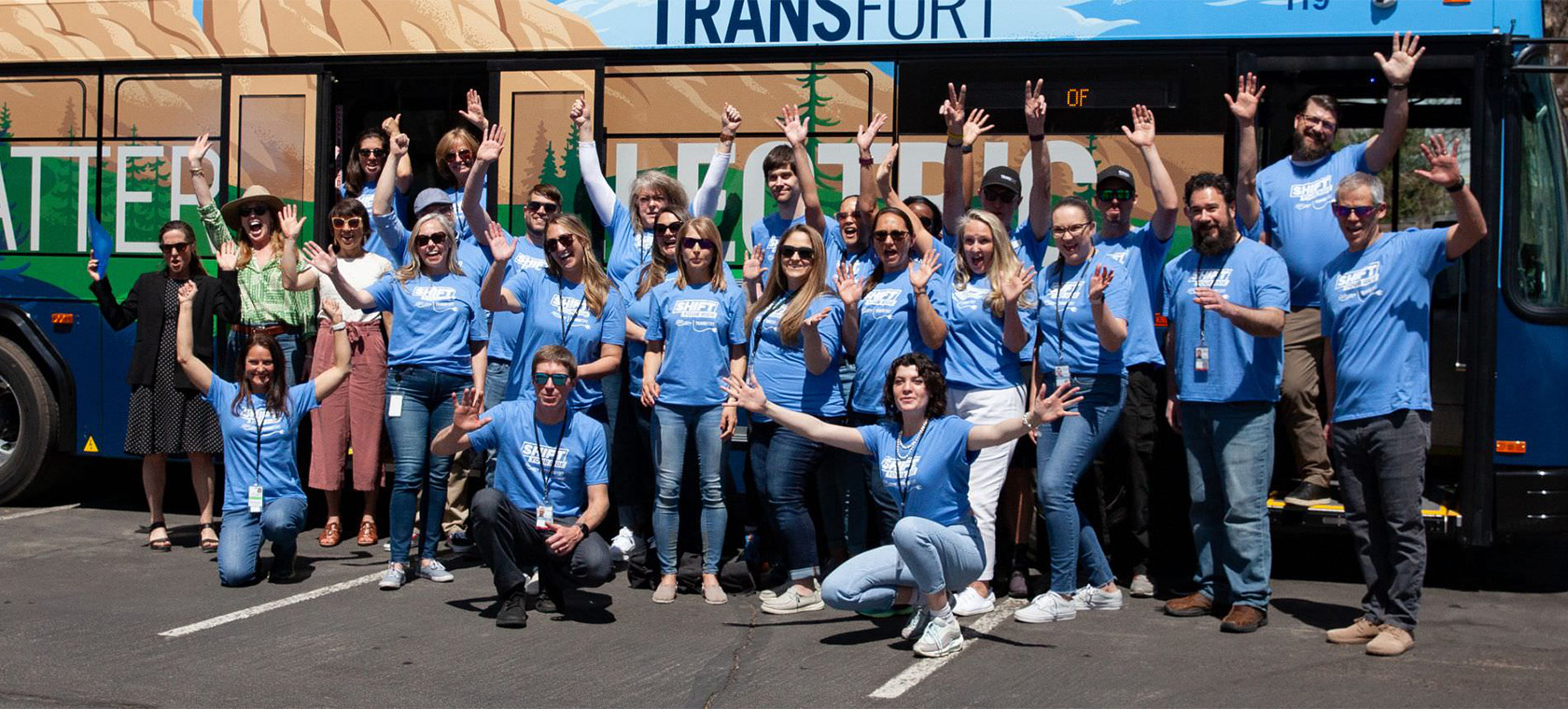 group of people posing in front of a bus