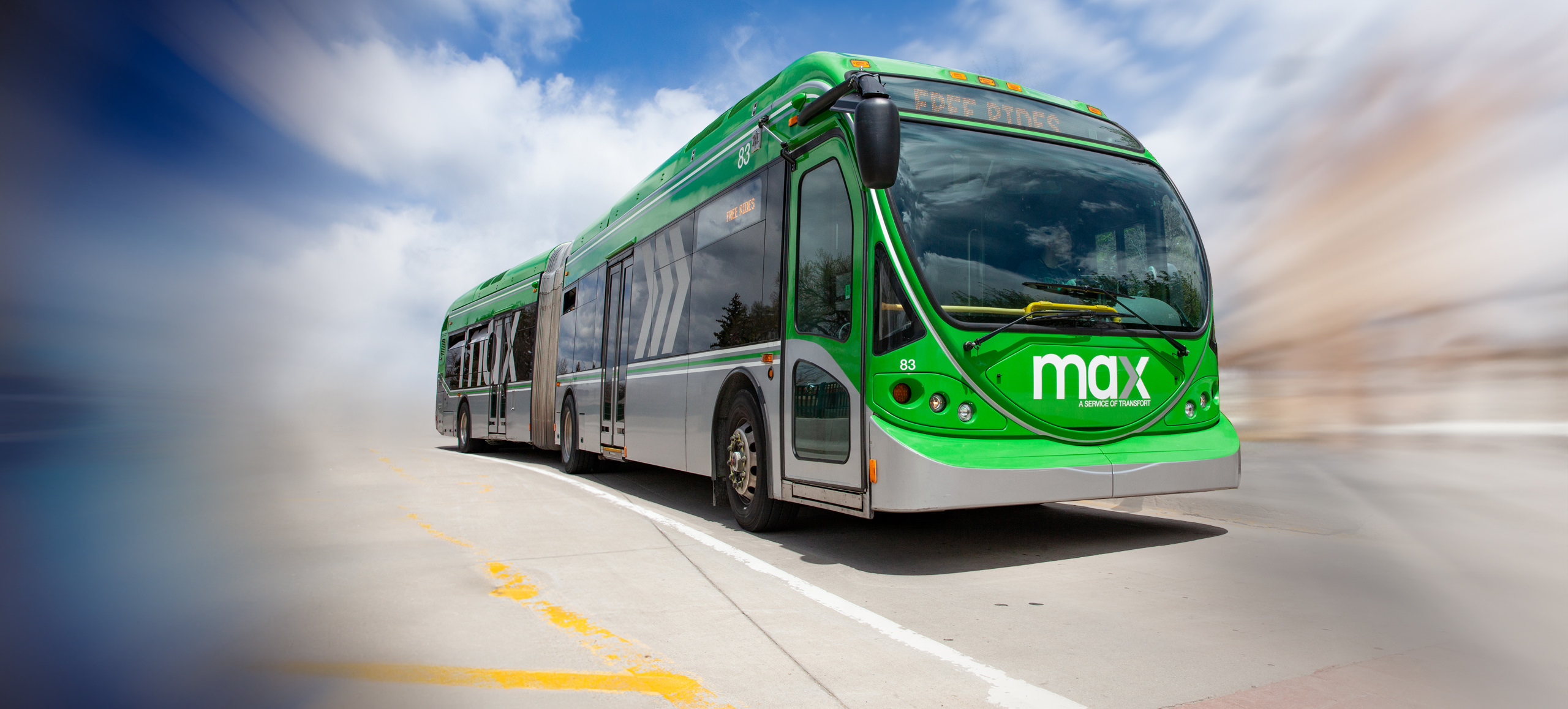 Background image showing green Max articulated bus with blurred background