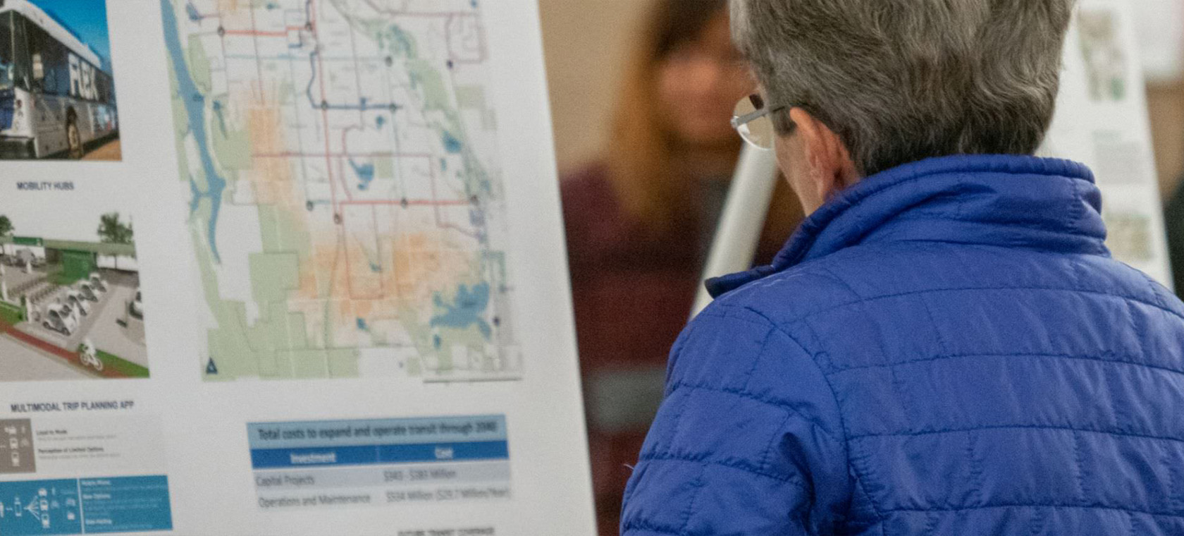 older person looking at map of bus schedules