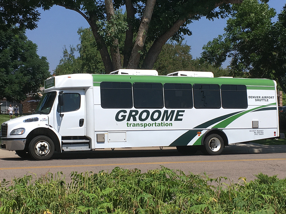 A Groom airport shuttle van sits on the roadside. 